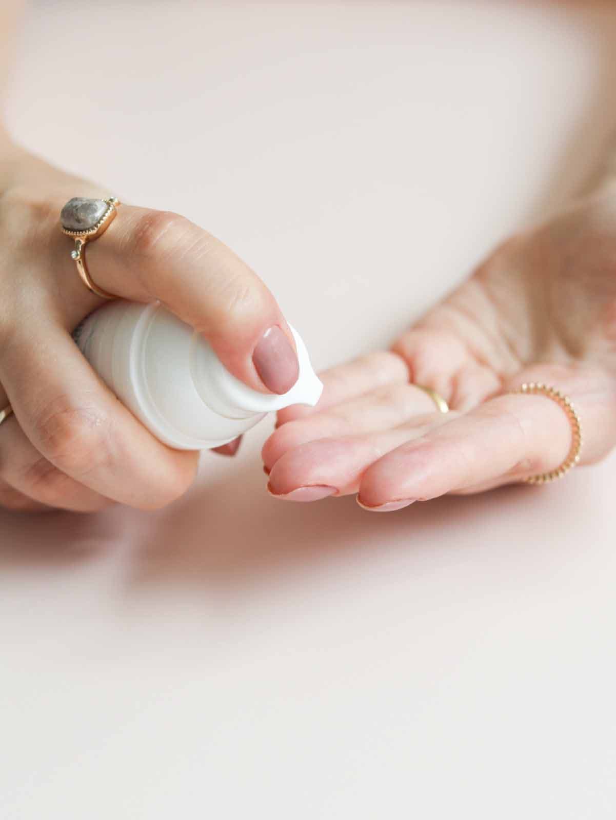 Nordic Oil社のCBDクリームを手に塗る女性。