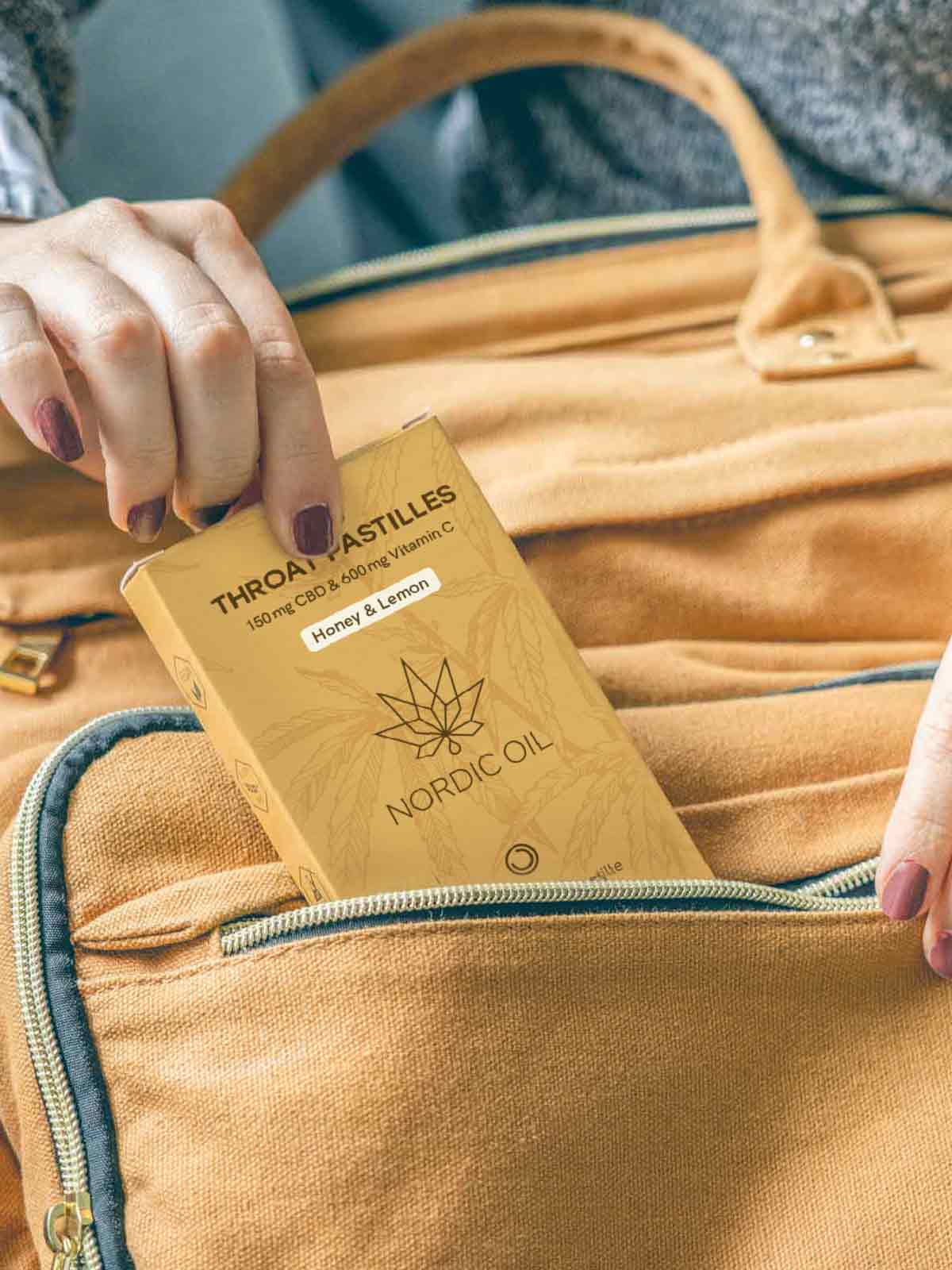 バッグからCBDのど飴(フレーバー:ハニーレモン)を取り出す女性。